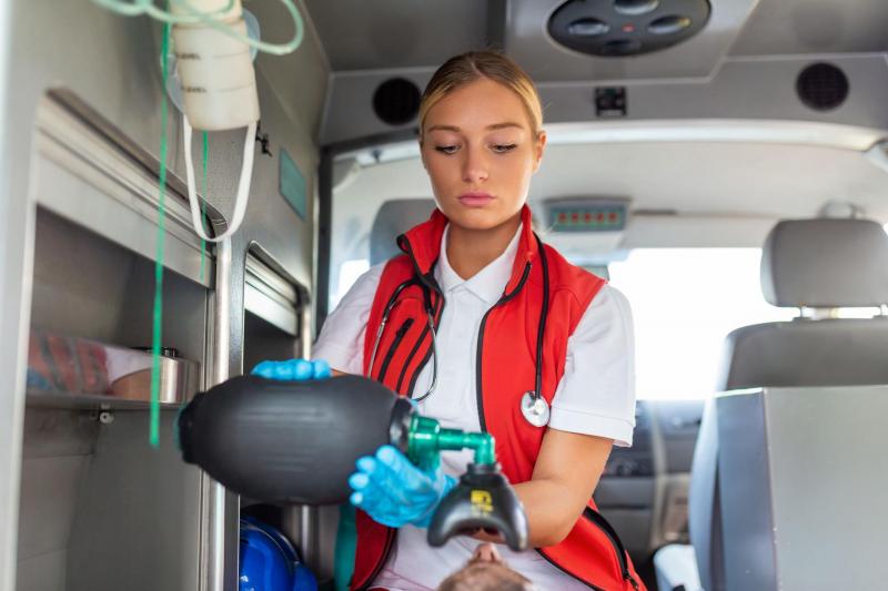 Ems paramedics provide medical help injured patient way hospital emergency care assistant putting ventilation mask with silicone manual resuscitators ambulance